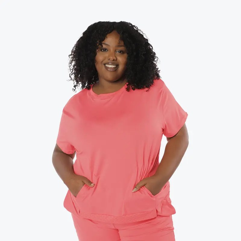 Woman with long dark hair wearing a fitted black long-sleeve scoop neck top with light wash jeans, posed at a slight angle against a white background